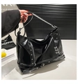 Dettaglio borsa tote in pelle verniciata nera con anelli e borchie punk argento - Nero