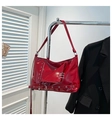 Dettaglio borsa rossa punk con anelli metallici, zip decorativa e cinturino con fibbia - Rosso