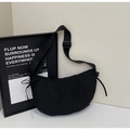 Detail of black crescent shoulder bag featuring adjustable strap and side drawstring knots - Black