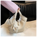 Detail of beige pebble leather bucket bag with matching mini pendant charm and snap closure - Off White
