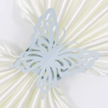 Detalle de un servilletero de mariposa azul claro cortado con láser y diseño intrincado - Azul Pálido Perla