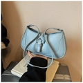 Detail of light blue crescent underarm bag showing smooth texture and strap buckle decoration - Blue