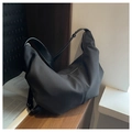Detail showing vertical pleated texture and leather strap of the black crescent bag - Black