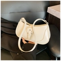 Chic cream-colored crescent underarm bag with decorative buckle on a black chair - White