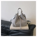 Detail view of the drawstring closure and adjustable strap on the nylon bucket bag - Gray