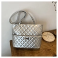 Detailed macro view of silver quilted tote bag with metallic logo and zipper texture - Silver