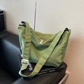 Large fruit green nylon tote bag with wide strap on a modern black leather sofa - Green