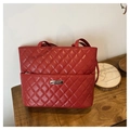 Detailed close-up of red quilted rhombic pattern tote bag with metal brand name plate - Red