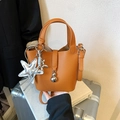 Bolso bombonera marrón textura lichi con colgantes plateados y correa ajustable - Marrón con colgante