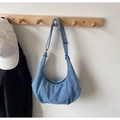 Λεπτομέρεια της μπλε denim τσάντας hobo με ρυθμιζόμενο λουράκι σε ξύλινο γάντζο τοίχου - Ανοιχτό μπλε
