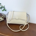 Chic off-white leather underarm bag with pebbled texture and adjustable strap - Beige