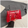 Detailed view of glossy red handbag featuring silver buckles and metallic chain strap - Red