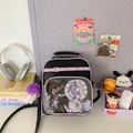 Détail du sac ita noir avec fenêtre transparente et peluche violette sur un bureau - Violet