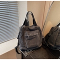 Détail du sac à dos en jean noir vintage montrant la texture délavée et la poche zippée - Noir
