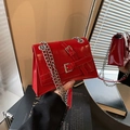 Chic red patent leather crossbody bag featuring silver buckles and chain strap - Red
