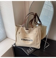 Grand sac cabas en toile beige avec anses en cuir marron et lettrage noir imprimé - Kaki