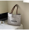 Détail du sac fourre-tout en toile avec poignées en cuir marron et poche avant - Gris clair