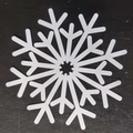 Detailed top view of white snowflake cutout coaster on a textured black surface - Snowflake Style B(B)