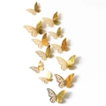 Detailed view of 12pcs gold 3D butterflies with hollow floral patterns on white wall - Set / Mirror Gold