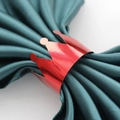 Détail d'un rond de serviette couronne rouge brillant sur du satin vert élégant - Rouge Vif Réfléchissant