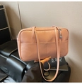 Sac bandoulière rose en cuir ciré montrant le grain fin et le détail de la poche avant - Rose