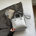 Sac fourre-tout argenté métallisé avec texture plissée et bandoulière sur lit blanc - Argent Sans Pendentif