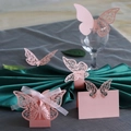 Macro view of laser-cut pink paper butterfly gift box and decorative napkins ring - Candy Box + Place Card + Cup Card + Napkin Ring + Wall Decal / Pink