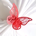 Macro detail of laser-cut red butterfly napkin ring on white satin fabric - Pearlescent Red