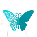 Detail of teal laser-cut paper butterfly place card on a glass rim for table decor - Tiffany Blue