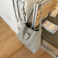 Bolso tote tipo cubo minimalista de cuero granulado gris claro colgado en silla madera - Azul grisáceo
