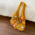 Dettaglio borsa tote gialla all'uncinetto con fiori 3D colorati su lenzuola bianche - Giallo