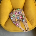 Borsa tote intrecciata kaki fatta a mano con fiori 3D colorati su divano giallo - Cachi