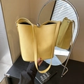 Chic yellow lychee leather bucket bag with a silver spherical metal clasp and strap - Yellow