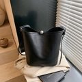 Fashionable black bucket bag in lychee texture leather with metal sphere clasp - Black
