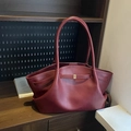 Minimalist burgundy leather tote bag with unique wing shape and golden buckle detail - Red