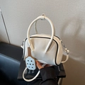 Bolso Boston blanco con ribetes negros y un elegante colgante de raqueta de ping-pong - Blanco Roto
