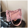 Detailed macro view of pink patent leather handbag with bow and silver brand logo - Purple