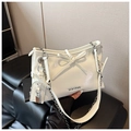 Detail of white patent leather underarm bag with silver chain and bow accent - Off White