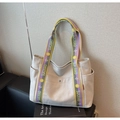 Detail of canvas tote bag featuring wide yellow and purple logo straps and side pockets - Rice White & Purple