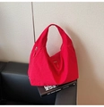 Primer plano del bolso hobo de nailon rojo con bolsillos de cremallera en sofá de cuero negro - Rojo