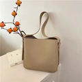 Bolso tipo cubo beige con textura lichi y correa ancha en exhibición elegante - Caqui