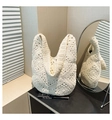Detailed view of white hollow-out crochet pattern on a stylish summer woven shoulder bag - Beige
