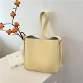 Bolso cubo de cuero granulado amarillo pálido con correa ancha y letras discretas - Amarillo leche