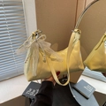 Light yellow crescent underarm bag with lace bow and pearl charm shown in hand - With Charm / Yellow