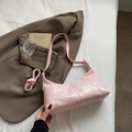 Light pink glossy faux leather crescent bag with adjustable straps in a lifestyle setting - No Pendant / Pink