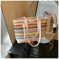 Detailansicht der bunten gewebten Strohtasche mit Markenlabel und Ledergriffen - Rosa