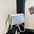Silver biker style crossbody bag with metallic woven edges and gold eyelet details - Silver