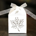 Macro detail of laser-cut maple leaf favor box with elegant white organza ribbon - White