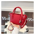 Red pebbled leather bucket bag with silver heart pendant and crossbody strap - Red