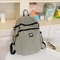 Detail of light green checkered nylon backpack with multi-zipper layers and brand logo - Gray